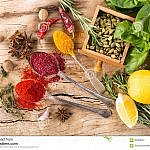 herbs-condiments-spices-wooden-background-87583447